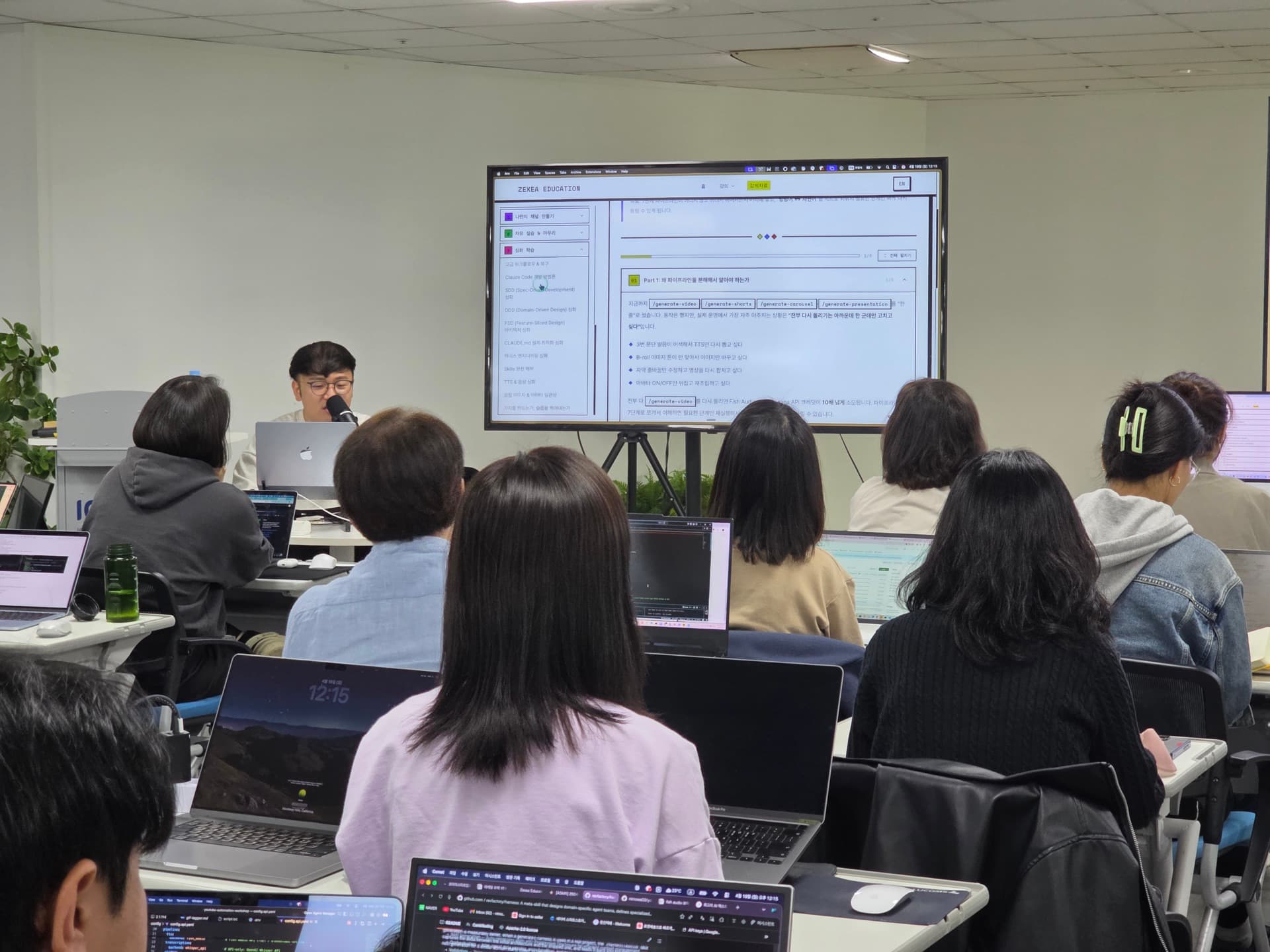 강사가 마이크를 들고 자동화 시스템을 설명하는 모습